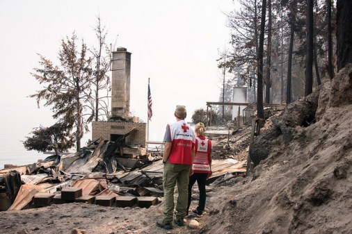 Red Cross Disaster Mental Health and Health Services volunteers Brett Wenger and Dawnda Smith view the remains of a home in Northeastern Washington that was completely destroyed by the wildfires. Photo Credit: Maggie Buckenmayer/American Red Cross 