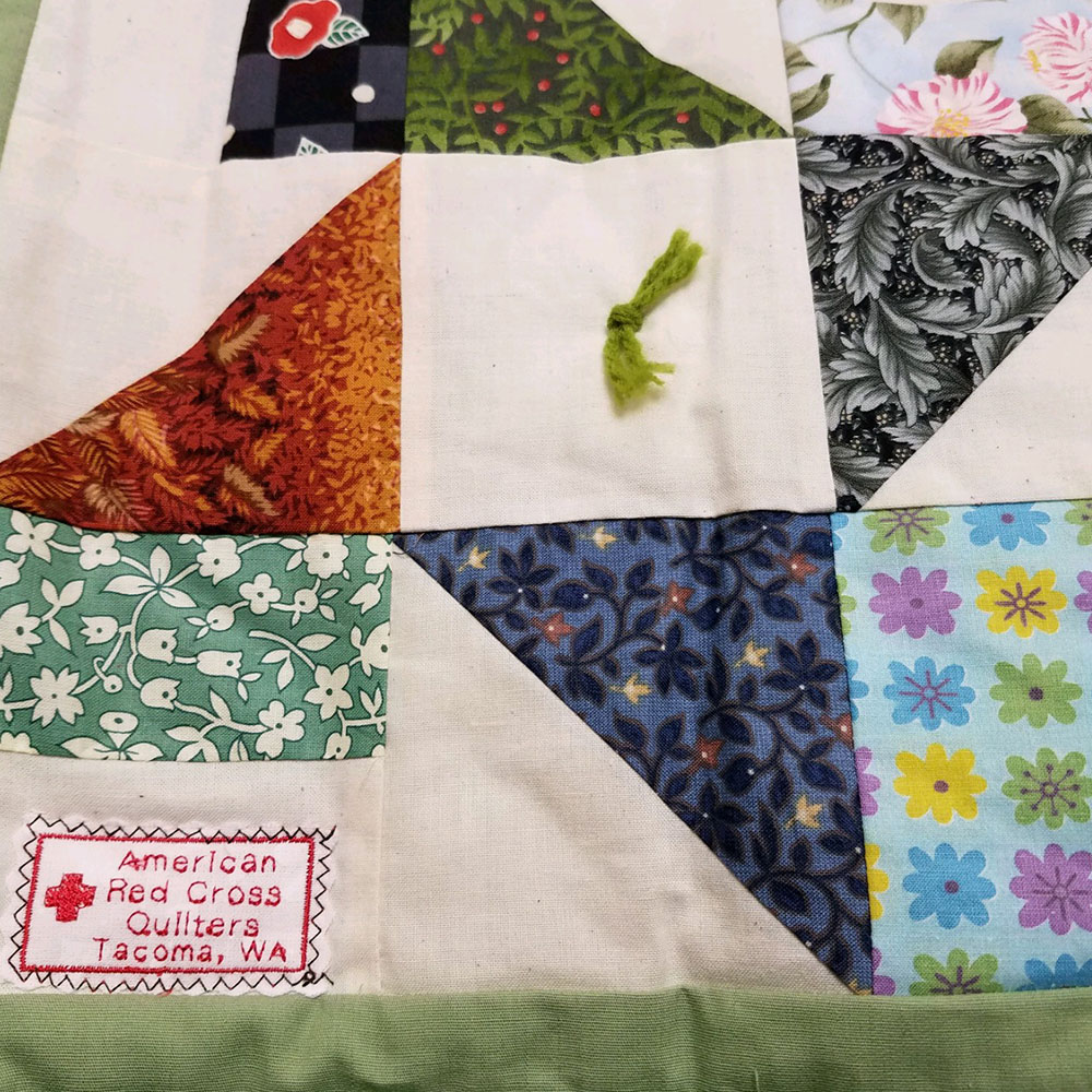 quilt with red cross stitching